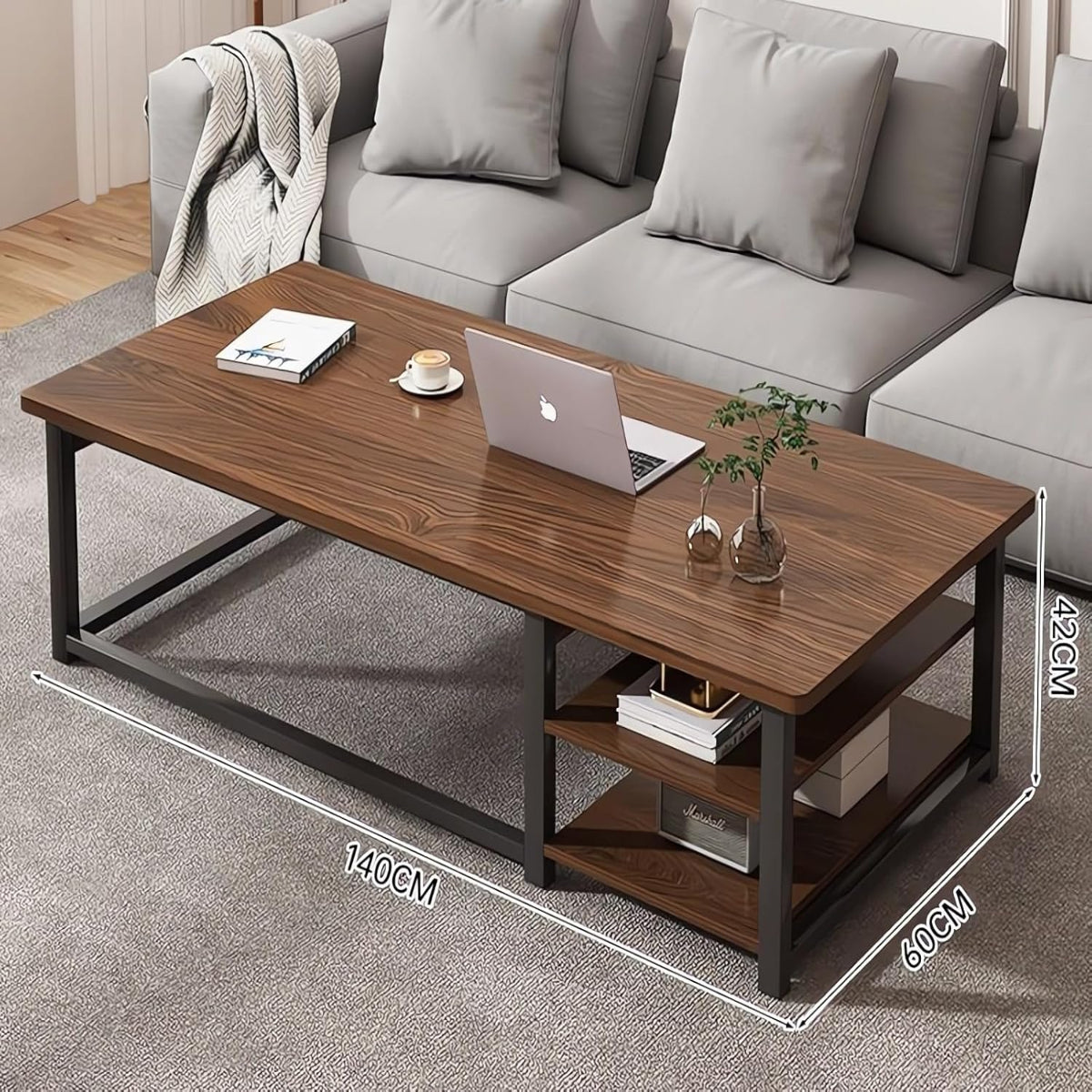 Wooden coffee table with laptop, books, and a plant in a living room setting.